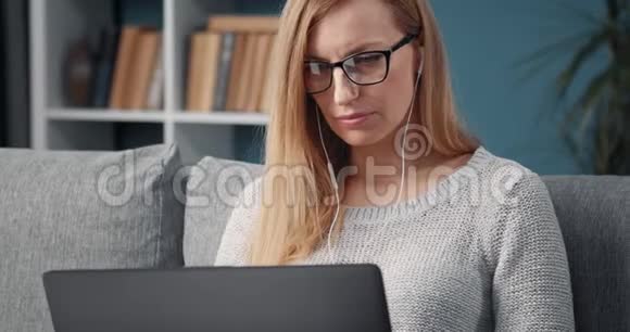 有魅力的女人用笔记本电脑在家里做远程工作视频的预览图
