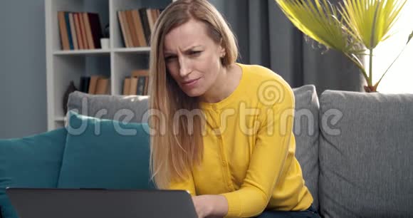 感情用事的女人在家里用电脑视频的预览图