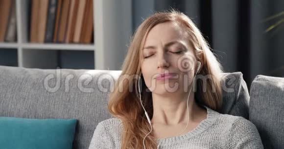 放松的女人用耳机听音乐视频的预览图