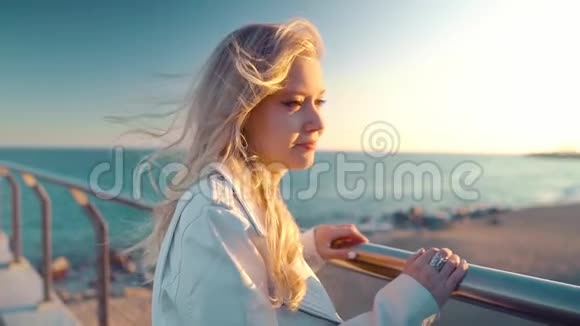 日落时分女人沿着美丽的海滩桥台散步视频的预览图