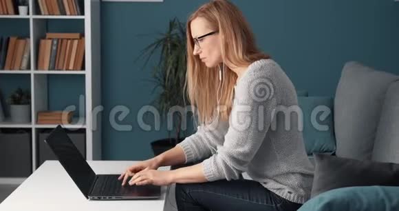 坐在沙发上工作的女性自由职业者视频的预览图