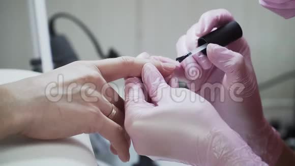 在美容院女孩涂指甲油去修指甲美与健康的主题特写视频的预览图