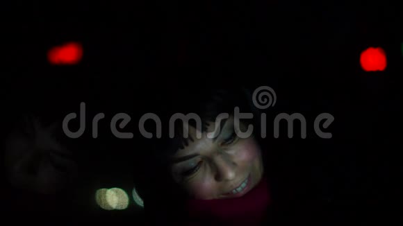 女人晚上在车里用智能手机视频的预览图