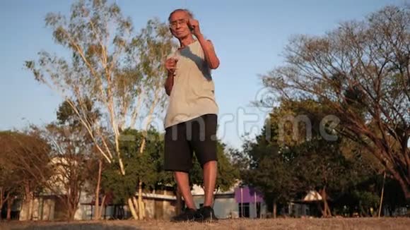在阳光明媚的日子里亚洲老人在公园里慢跑以保持身体健康保健概念视频的预览图