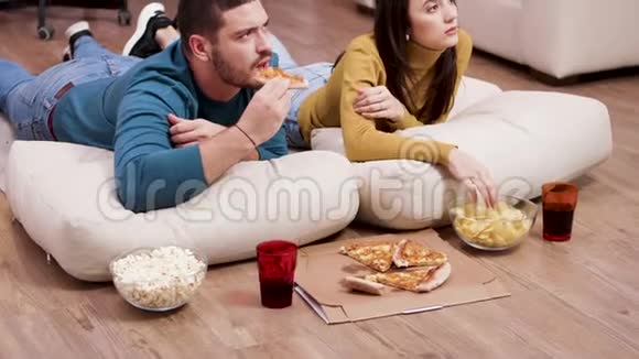 年轻夫妇在电视上看恐怖电影视频的预览图