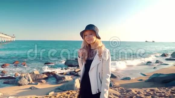 日落时分年轻女子在美丽的海边散步视频的预览图
