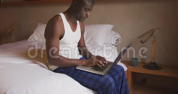 非裔美国人在卧室里用电脑视频的预览图