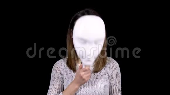 一个年轻的女人摘下面具脸上露出悲伤女孩伤心地看着相机女人掩着脸视频的预览图