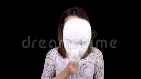 一个年轻的女人摘下面具脸上流露出愤怒的情绪女孩对着镜头皱眉女人把她藏起来视频的预览图