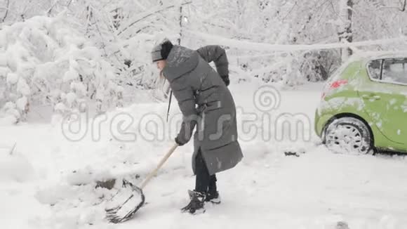 拿着铲子的少女在后院铲雪视频的预览图