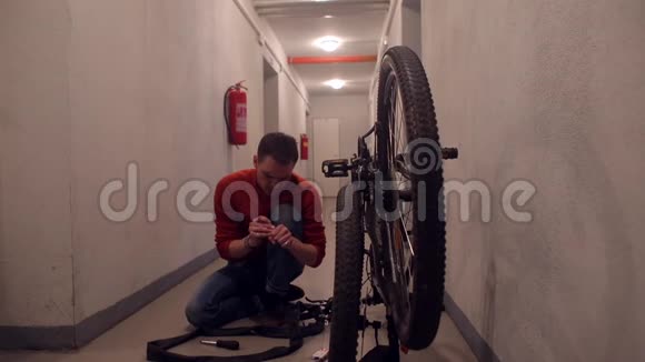 机械师在车库里用自行车轮的橡胶做操纵视频的预览图
