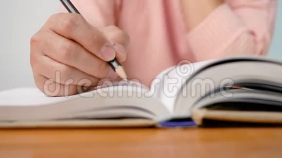 在图书馆阅读一本书的时候把的手画一条线写一篇简短的摘要视频的预览图