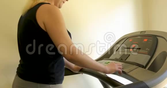穿着运动服的无名胖女在家跑步机上工作视频的预览图
