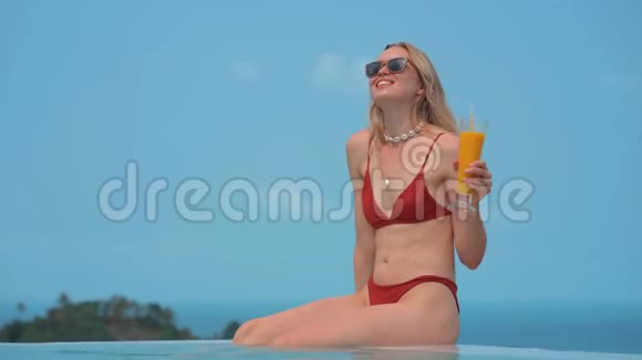 美丽的金发美女穿着红色泳衣度假休息视频的预览图