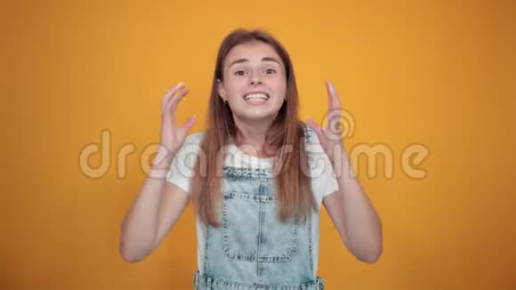 穿着白色t恤的年轻女性橙色背景显示出情绪视频的预览图