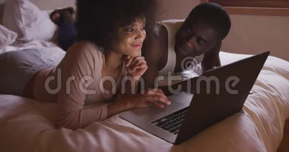 一对夫妇在家里的卧室里用电脑视频的预览图