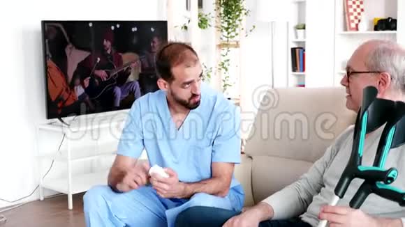 年轻的医生帮助老人吃药视频的预览图