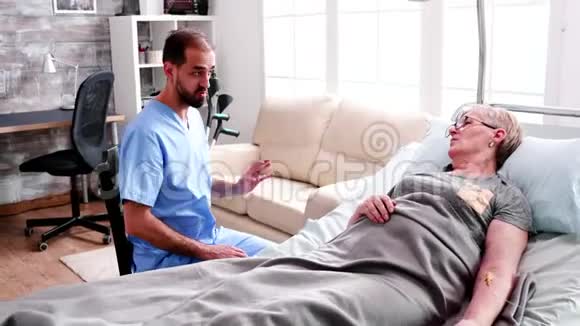 在疗养院的白种人医生和老妇人谈话视频的预览图