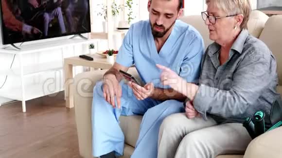退休家庭的男护士帮助老年妇女使用电话视频的预览图