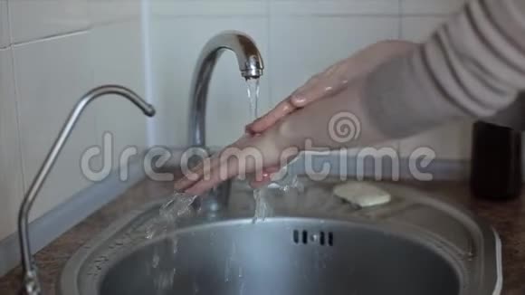 白人年轻女子用水彻底洗手特写视频的预览图