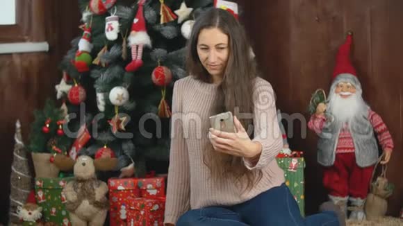 女孩坐在圣诞树附近自拍视频的预览图