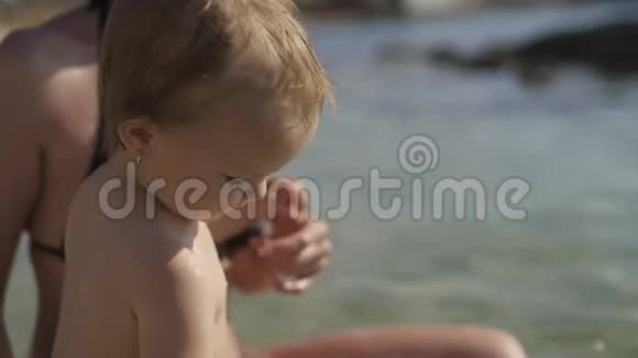两岁女孩的肖像孩子站在水里对着镜头微笑早上好克罗地亚视频的预览图