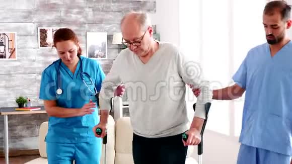 年轻的男医生和帮助老人的女人视频的预览图