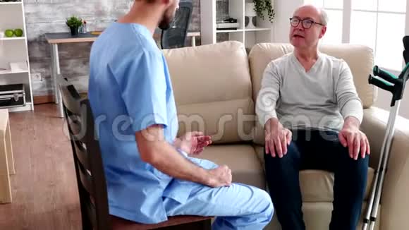 年轻有胡子的医生在和老人说话视频的预览图