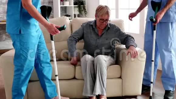 拄拐的老年妇女由护士小组协助视频的预览图