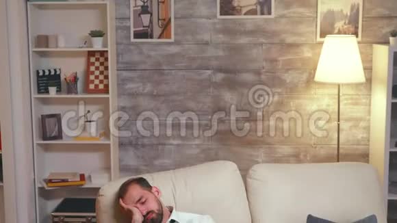 工作过度的商人睡在沙发上视频的预览图
