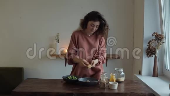 在餐桌旁的厨房里一个漂亮的小女孩手里拿着一个烤架准备着美味健康的食物视频的预览图