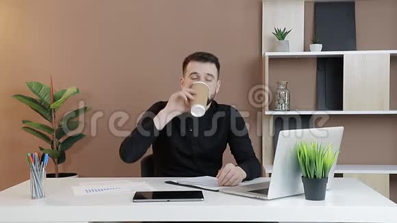 商人在工作场所喝咖啡办公室工作人员在电脑旁喝咖啡视频的预览图