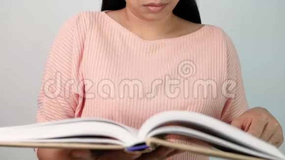 女人翻书页在图书馆看书时她的手指沿着书页移动有选择的焦点视频的预览图