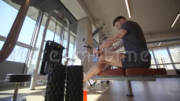 在健身房使用坐排机的年轻人视频的预览图