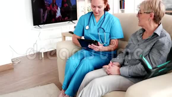 女护士在养老院拿着平板电脑视频的预览图