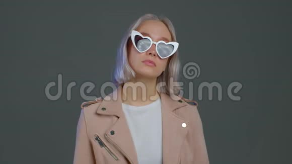 漂亮的时髦女人头发是金色的灰色的心形太阳镜视频的预览图