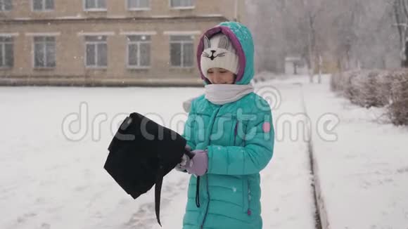 冬天雪下的小女孩露出黑色的伞视频的预览图