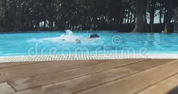 一个男人和一个男孩在游泳池边游泳时拍的稳定的镜头视频的预览图