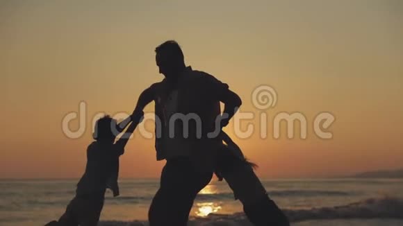 一个人在夕阳的天空中旋转着他的两个孩子视频的预览图