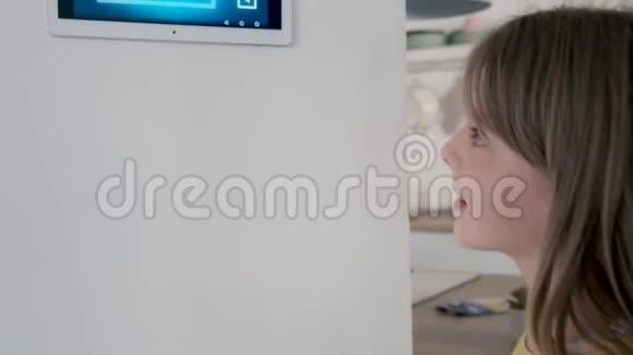 特写小女孩使用带有数字平板电脑的domotic系统在家里视频的预览图