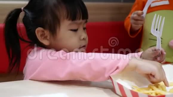 亚洲同胞小女孩喜欢吃炸鸡薯条和花蜜在服务商店与她的家人肯德基是一家视频的预览图