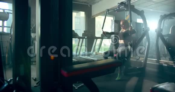 运动女孩在健身房与啄木甲板机接触视频的预览图