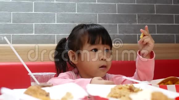 亚洲同胞小女孩喜欢吃炸鸡薯条和花蜜在服务商店与她的家人肯德基是一家视频的预览图