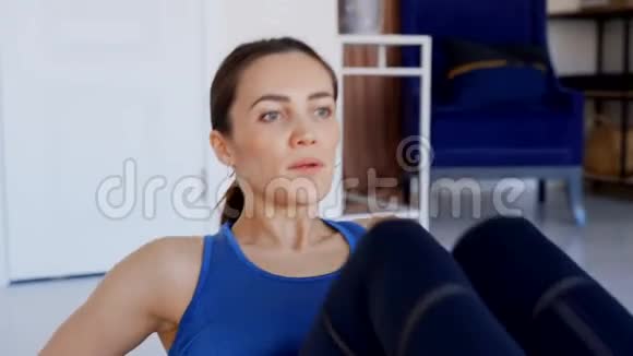 漂亮的黑发女人对腹部肌肉进行锻炼视频的预览图