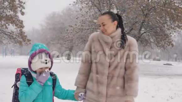 妈妈和女儿在冬天放学回家视频的预览图
