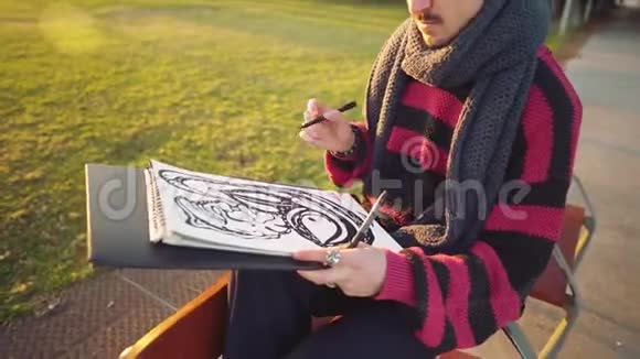 现代年轻时尚男画家在公园画素描视频的预览图