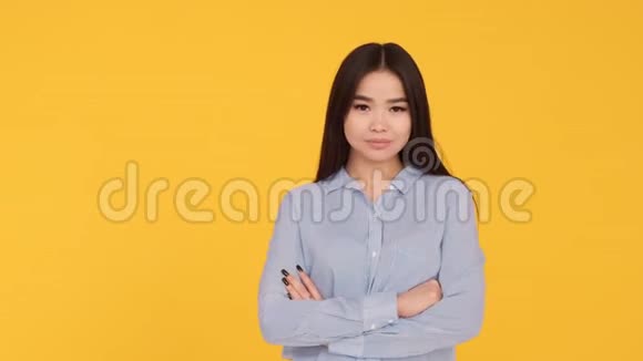 黄色背景的年轻亚洲女孩发出空气的亲吻和微笑视频的预览图