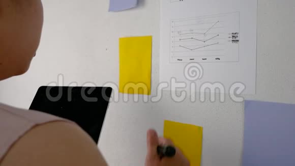 严肃的亚洲女性商业写作商业计划并将她的想法放在白板上女人拿着平板电脑做笔记视频的预览图