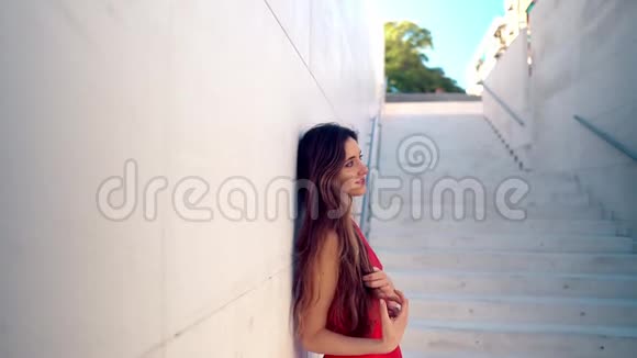 美丽的女人穿着红色优雅的裙子城市白人背景视频的预览图