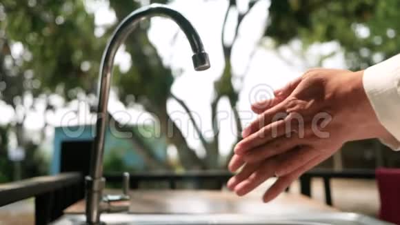女人用肥皂在水槽上的流水下洗手卫生保健理念视频的预览图